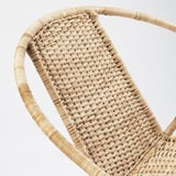 Primer pla de la cadira de canya teixida, que mostra un teixit complex i una textura natural.