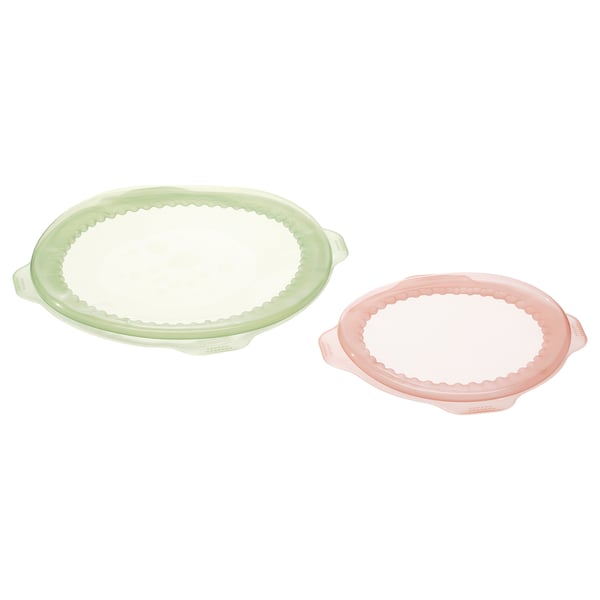 Dues fundes d'aliments de silicona de color verd i rosa. Són rodons i reutilitzables, dissenyats per cobrir i emmagatzemar aliments.