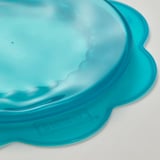 Coberta d'aliments de silicona de color blau brillant, flexible, s'adapta a diverses formes.
