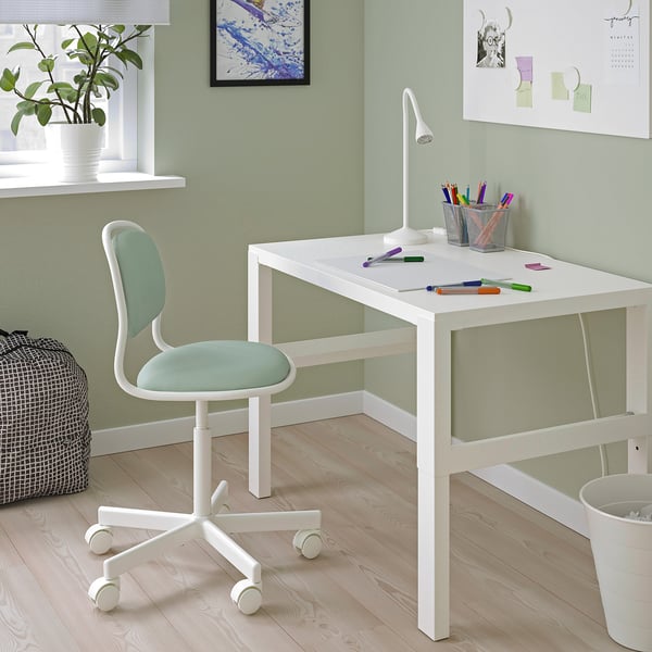 Escriptori i cadira per a nens blancs de PÅHL/ÖRFJÄLL. Disseny minimalista, paret verda, planta, llum, llapis.
