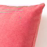 Coixí vermell amb una textura llisa, amb variacions de color naturals, que mostra materials reciclats d'alta qualitat.