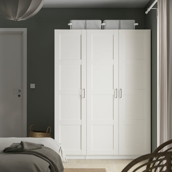 Armari PAX blanc modern, alt amb quatre portes, al costat del llit.