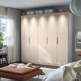 Armari ikea PAX marró amb múltiples portes, il·luminació led i banc.