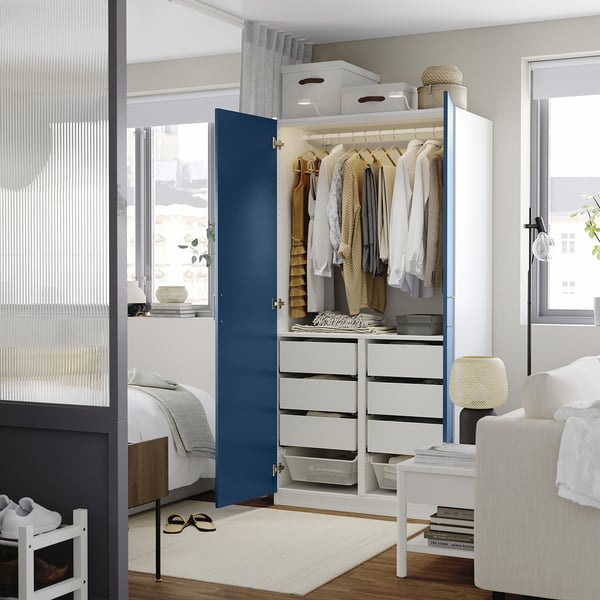 Dormitori modern amb armari modular blanc i blau i emmagatzematge.