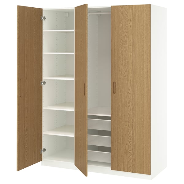 Un armari obert de fusta PAX. Té portes de roure clar i interiors blancs amb prestatges i calaixos de malla.
