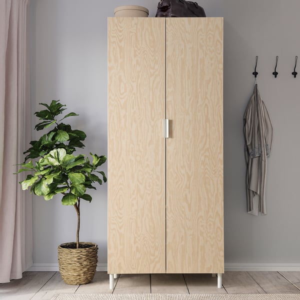 Armari de fusta PLATSA amb planta, cortines, jaqueta grisa.