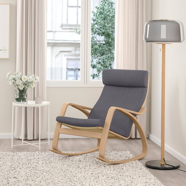 Sala d'estar moderna amb balancí POÄNG, llum i catifa estampada.