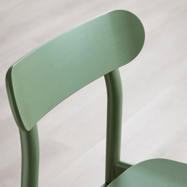 Cadira moderna de color verd menta amb respatller corbat i acabat llis.