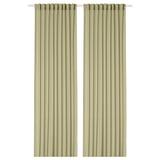 Dues cortines de color verd oliva transparent pengen una al costat de l'altra, amb butxaques de vareta a la part superior. Fabricat amb polièster 100% reciclat.