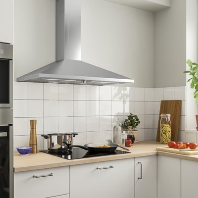 Cuina moderna amb campana inoxidable RYTMISK, armaris blancs, taulell de fusta, estufa amb olles i diversos ingredients.
