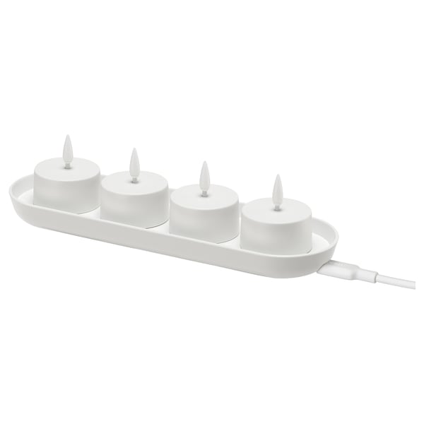 Imatge SKATGÅS led tealights, blanques, en una safata de càrrega. Quatre espelmes cilíndriques amb puntes en forma de flama, connectades per un cable blanc.