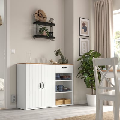 Sala d'estar moderna amb aparador blanc SKRUVBY, planta en test i prestatgeries de paret. Disseny net i minimalista.