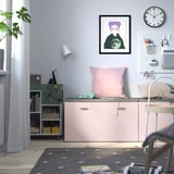 Configuració d'oficina a casa amb banc SMÅSTAD, coixins, auriculars, llum, prestatgeria i decoració.