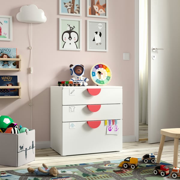 Habitació infantil amb cofre SMÅSTAD, joguina d'astronauta, rellotge de colors, prestatgeria i catifa de carretera.