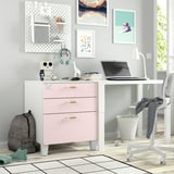 Configuració d'escriptori infantil petit i modern amb calaixos roses i blancs, motxilla grisa, auriculars de color verd clar i art de paret de colors.