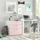 Espai de treball domèstic amb calaixos SMÅSTAD rosa, tauler perforat, escriptori, ordinador portàtil, llibres i decoració personal.