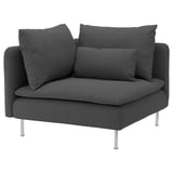 Còmode sofà gris fosc, cadira moderna amb potes metàl·liques elegants, coixins a joc, acollidora i elegant.