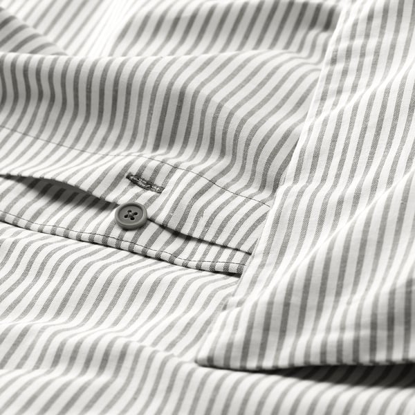 Camisa de ratlles grises amb botó central desfet, mostrant detall de recompte de fils. Primer pla de la textura i les costures del teixit.