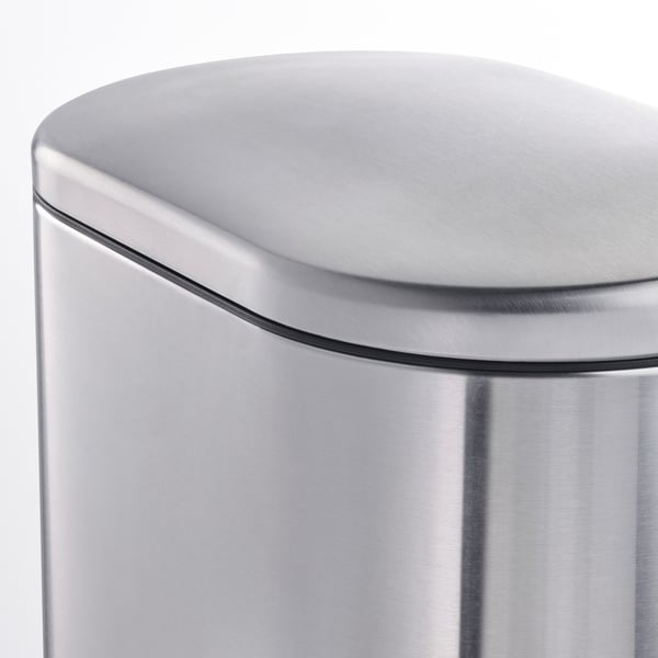 Primer pla d'un elegant contenidor d'escombraries d'acer inoxidable corbat, vora llisa de la tapa, que mostra el seu disseny modern i resistent.