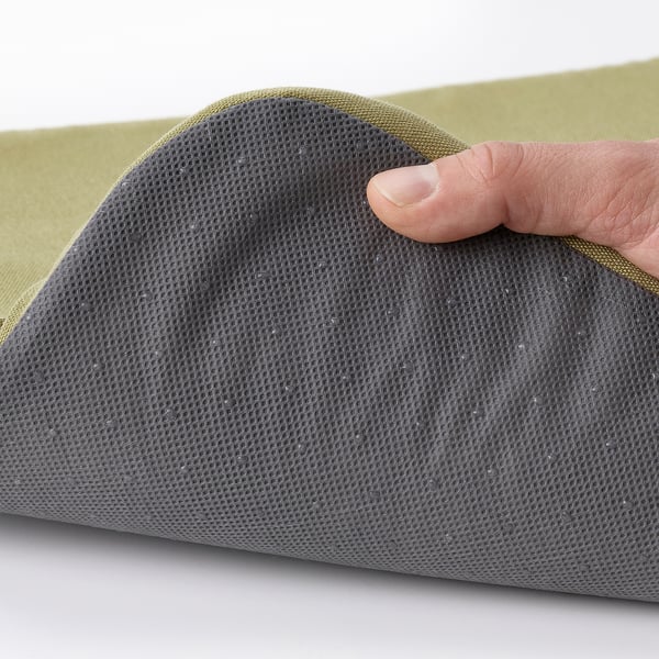 Tocant a mà la superfície de malla grisa del coixinet de la cadira STAGGSTARR, mostrant la funda extraïble i rentable.