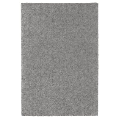 Una catifa STOENSE rectangular grisa amb una superfície suau i texturitzada, perfecta per afegir confort i estil a les habitacions.