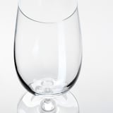 Una copa de vi clara i elegant amb una tija llisa, que reflecteix la llum, sobre un fons blanc.