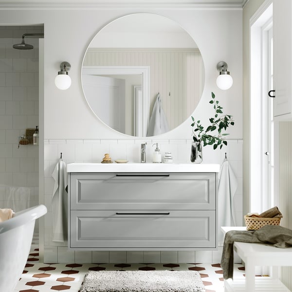 Bany modern: tocador TÄNNFORSEN, calaixos, mirall, llums, taulell, catifa, terra a quadres.