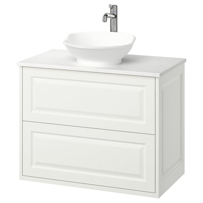 Tocador de bany modern de paret blanc amb lavabo arrodonit i aixeta cromada.
