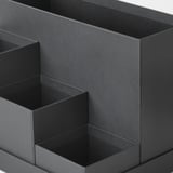 Organitzador d'escriptori negre de cinc compartiments, amb diverses mides, fabricat amb materials reciclats.