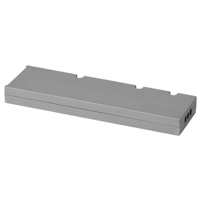 Controlador d'il·luminació intel·ligent TRÅDFRI rectangular gris amb carcassa de plàstic i ports de connexió blancs.