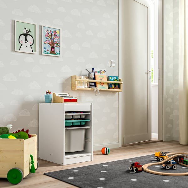 Sala de jocs infantil amb emmagatzematge TROFAST, material d'art, llibres, paperera de joguines i cotxes.