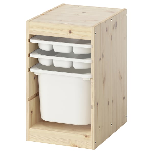 Un traster TROFAST, de fusta clara, amb tres safates blanques i un gran contenidor blanc. Té una forma rectangular i un disseny frontal obert.