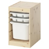 Un traster TROFAST, de fusta clara, amb tres safates blanques i un gran contenidor blanc. Té una forma rectangular i un disseny frontal obert.