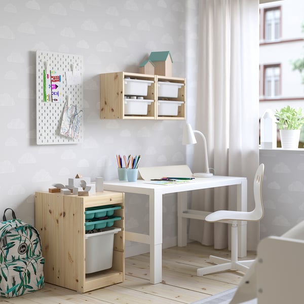 Zona d'estudi infantil moderna amb escriptori i cadira TROFAST, emmagatzematge de joguines, obres d'art i finestra.