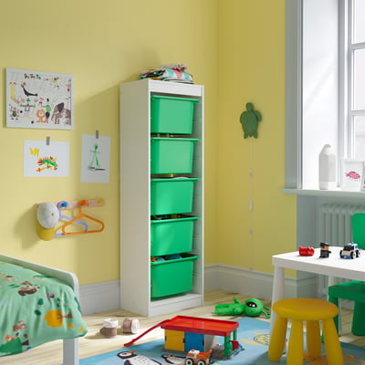 Habitació infantil amb traster TROFAST, contenidors verds, parets grogues, joguines de colors, art, llit petit.