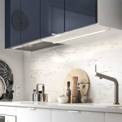 Cuina moderna amb backsplash de marbre, aixeta inoxidable i campana de cuina elegant.