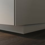 El sòcol UPPLÖV en beix mat s'adapta als armaris, amagant el buit del terra.