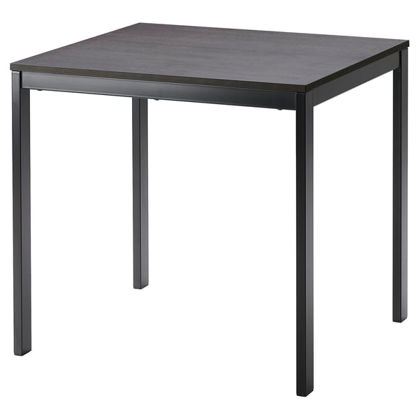 Una taula de menjador extensible VANGSTA en color negre amb tapa de fusta fosca, forma rectangular i potes metàl·liques resistents. Ideal per a seients espaiosos.