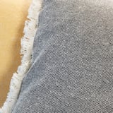 Primer pla de la catifa teixida i texturitzada amb serrells, ratlles grises i blanques.