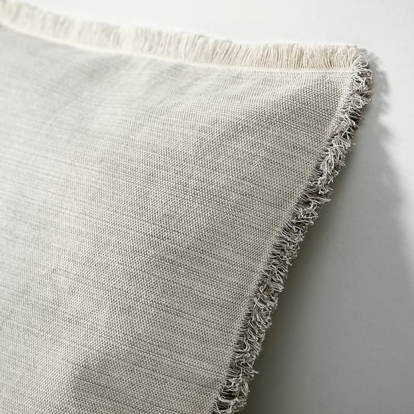 Són fundes de coixí de serrells blancs, grises i blanques amb una textura teixida, plegades ordenadament sobre una superfície plana.