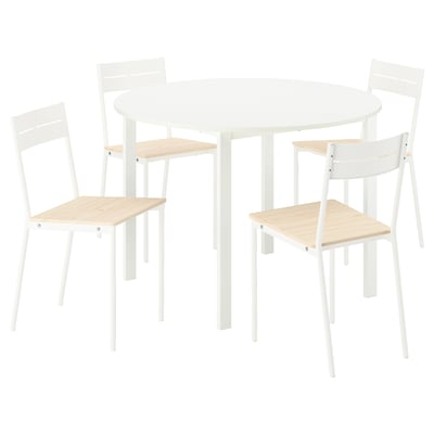 Taula de menjador rodona blanca amb quatre cadires a joc. Disseny modern i minimalista amb marcs metàl·lics i seients de fusta.