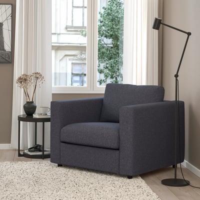 Sala d'estar moderna amb sofà gris VIMLE, llum de peu elegant, taula auxiliar i catifa. El sofà és compacte però acollidor, que s'adapta còmodament.