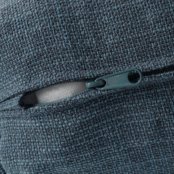 Primer pla de la cremallera duradora sobre la funda del sofà de tela suau i texturitzada.