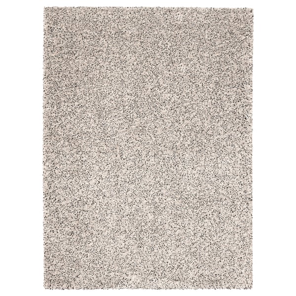 Una catifa VINDUM, de color beix clar, rectangular, amb una textura peluda.