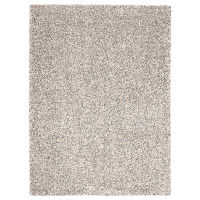 Una catifa VINDUM, de color beix clar, rectangular, amb una textura peluda.