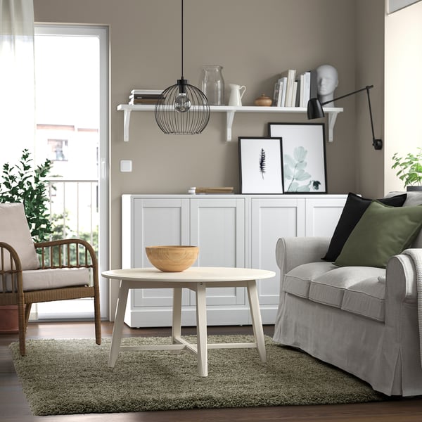 Sala d'estar amb catifa, cadira, taula i decoració de paret VOLLERSLEV.