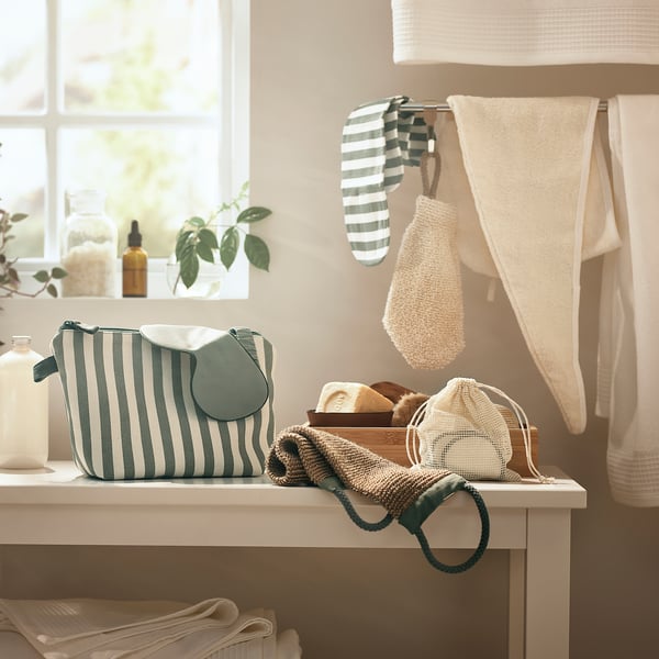 Bathroom counter with striped bag, knit pouches, towels, and bottles.