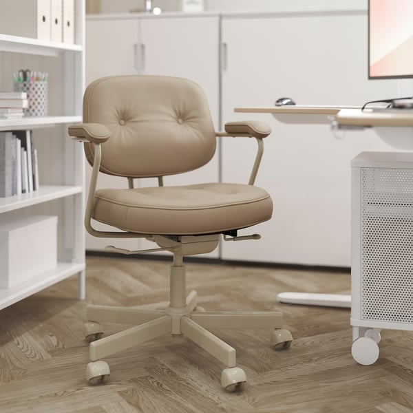Modern home office: beige leather ergonomic chair with adjustable armrests, casters, in minimalist white room.