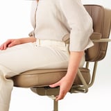Person adjusting office chairs armrest.