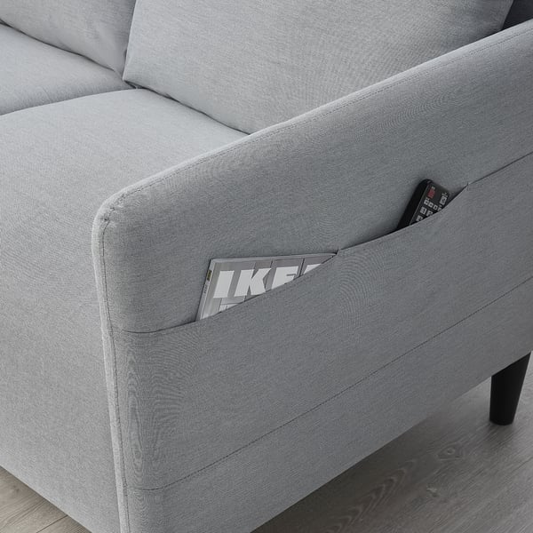 Gray sofa with side pocket holding a remote.